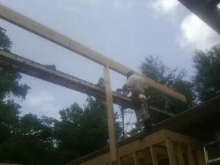 Carpenter setting a ridge beam over a new addition frame — Ice Dam Removal by Roofing Brothers in Mohler